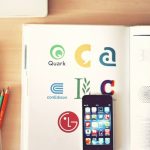 A desk with books a phone and stationary on it