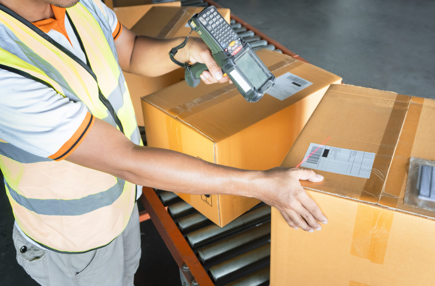 Man in a warehouse using a hand-held scanner scanning inventory